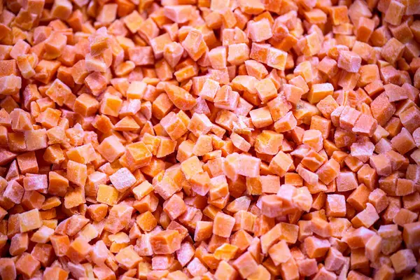 İnce buz kaplamalı dondurulmuş kırmızı dolma biber küplerinin yakın çekimi. Perakende satışlar ve bozulabilir hasatların korunması için uzun raf ömrü sağlamak üzere ambalaj işlemine hazırlandı.