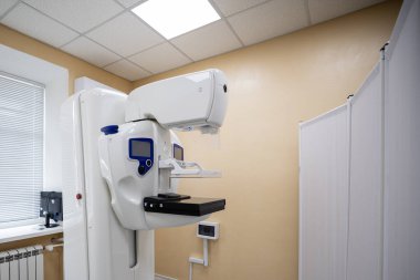 Çift etkileşimli ekranları olan modern bir mammografi makinesi, temiz bir tıbbi odada, tanı taraması için hazır bekliyor.