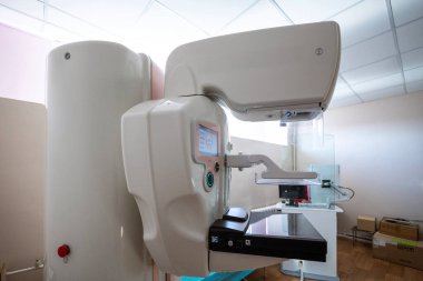 Çift etkileşimli ekranları olan modern bir mammografi makinesi, temiz bir tıbbi odada, tanı taraması için hazır bekliyor.