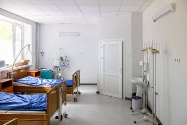 Çok yataklı bir hastane koğuşunda her birinde akciğer solunum cihazı, oksijen konsantratörü ve oksijen merkezi bulunan üç boş yatak bulunur..