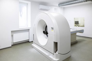 Hastanede modern bir tomografi tarayıcısı. Hasta masası olan, bilgisayarlı bir tomografi makinesi, ve tesisin bodrum katında temiz bir sağlık odasında çeşitli yedek ekipman ve parlak duvarlar..