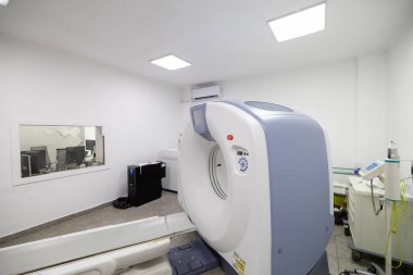 Hastanede modern bir tomografi tarayıcısı. Hasta masası olan, bilgisayarlı bir tomografi makinesi, ve tesisin bodrum katında temiz bir sağlık odasında çeşitli yedek ekipman ve parlak duvarlar..