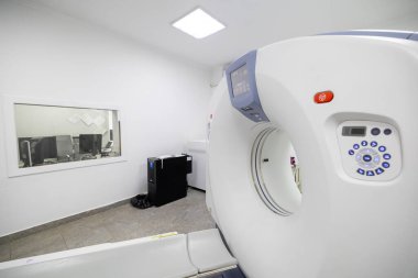 Hastanede modern bir tomografi tarayıcısı. Hasta masası olan, bilgisayarlı bir tomografi makinesi, ve tesisin bodrum katında temiz bir sağlık odasında çeşitli yedek ekipman ve parlak duvarlar..
