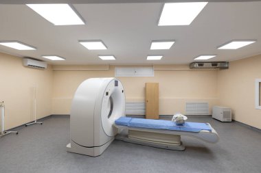 Hastanede modern bir tomografi tarayıcısı. Hasta masası olan, bilgisayarlı bir tomografi makinesi, ve tesisin bodrum katında temiz bir sağlık odasında çeşitli yedek ekipman ve parlak duvarlar..