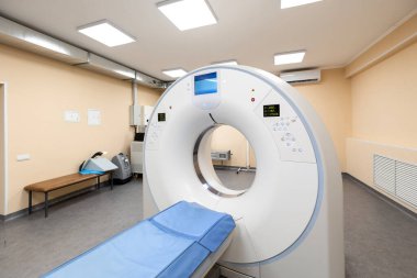 Hastanede modern bir tomografi tarayıcısı. Hasta masası olan, bilgisayarlı bir tomografi makinesi, ve tesisin bodrum katında temiz bir sağlık odasında çeşitli yedek ekipman ve parlak duvarlar..