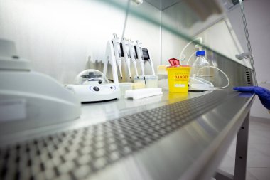 Pipetler ve bir karıştırıcı da dahil olmak üzere DNA / RNA çıkarma ekipmanı bir laboratuvardaki havalandırmalı güvenlik dolabında bulunuyor.
