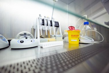 Pipetler ve bir karıştırıcı da dahil olmak üzere DNA / RNA çıkarma ekipmanı bir laboratuvardaki havalandırmalı güvenlik dolabında bulunuyor.