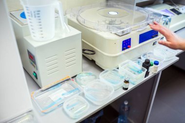 Bir santrifüj, ölçüm kabı ve test tüpleri ve tüpler gibi çeşitli tıbbi malzemeler bir çalışma tezgahına yerleştirilmiştir..