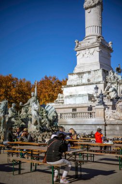 Bordeaux, Fransa - 23 Kasım 2021: İnsanlar Quinconces Meydanı 'ndaki sıcak sonbahar güneşli Weahter Anıtı ve Fontaine du Char du Triomphe de la Concorde yakınlarında dinleniyor.