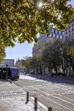 Bordeaux, Fransa - 23 Kasım 2021: Bir TBM tramvayı, Quinconces Meydanı 'ndaki Girondins Anıtı yakınlarındaki bir uçak ağacı sokağının altında son durağında..