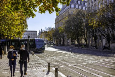 Bordeaux, Fransa - 23 Kasım 2021: Bir TBM tramvayı, Quinconces Meydanı 'ndaki Girondins Anıtı yakınlarındaki bir uçak ağacı sokağının altında son durağında..