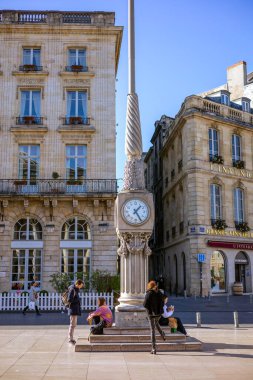 Bordeaux, Fransa - 23 Kasım 2021: Kamu saati Büyük Bordeaux Tiyatrosu 'nun karşısındaki Place de la Comedie' de uzun bir direğe bağlandı. Bordeaux, Gironde, Yeni Aquitaine, Fransa.