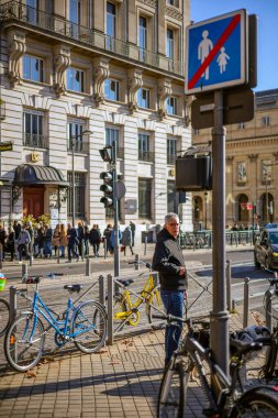 Bordeaux, Fransa - 23 Kasım 2021: Rue du 30 Temmuz 'da popüler L' Entrecote restoranında öğle yemeği kuyruğu. İki şehir bisikleti, sarı ve mavi, bir caddede çitin yanına park edilmiş. Bordeaux, Fransa.