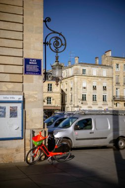 Bordeaux, Fransa - 23 Kasım 2021: Rohan Meydanı 'ndaki Bordeaux Belediye Binası' nın köşesinde süslü bir demir lamba, bir Lime araba paylaşım bisikleti ve bir şehir minibüsü bulunuyor. Bordeaux, Gironde, Yeni Aquitaine, Fransa.