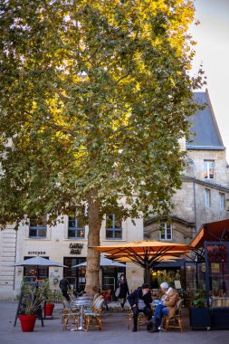 Bordeaux, Fransa - 23 Kasım 2021: PI 'de büyük bir sonbahar ağacı altında müşterileri olan açık hava kafe. Saint-Projet, Merkez Pansiyonun bitişiğinde. Bordeaux, Gironde, Yeni Aquitaine, Fransa.