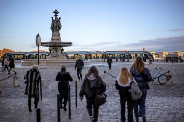 Bordeaux, Fransa - 23 Kasım 2021 Fontaine des Trois Graces 'in yer aldığı Place de la Bourse ve meydanında yayalar bulunan modern bir tramvay. Bordeaux, Gironde, Yeni Aquitaine, Fransa.