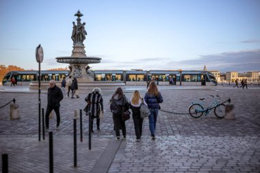 Bordeaux, Fransa - 23 Kasım 2021 Fontaine des Trois Graces 'in yer aldığı Place de la Bourse ve meydanında yayalar bulunan modern bir tramvay. Bordeaux, Gironde, Yeni Aquitaine, Fransa.