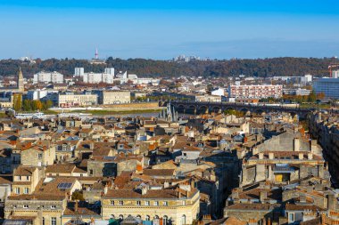 Garonne Nehri, Pont de Pierre ve Porte Cailhau 'nun yer aldığı orta ve doğu Bordeaux' nun panoramik manzarası, ön planda şehir çatıları. Bordeaux, Yeni Akitanya, Fransa.