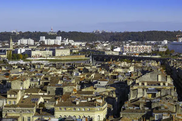 Garonne Nehri, Pont de Pierre ve Porte Cailhau 'nun yer aldığı orta ve doğu Bordeaux' nun panoramik manzarası, ön planda şehir çatıları. Bordeaux, Yeni Akitanya, Fransa.