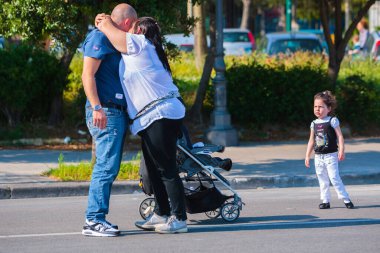 Napoli, İtalya - 27 Mayıs Akdeniz kıyısında yaz günü. İnsanlar rahatlar, yürürler, güneşlenirler ve deniz kenarındaki hayatın tadını çıkarırlar. Bebek arabasında çocuklu ebeveynler. 27 Mayıs 2012. Napoli, Campania, İtalya.