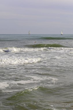 Valencia, İspanya 'da Malvarrosa' nın güneşli sonbahar plajlarında yaz titreşimleri. Deniz kıyısındaki engin, pürüzsüz kumlar tatilcileri köpüklü dalgalar boyunca yapayalnız yürüyüşlere çeker..