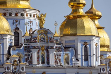 Ukrayna 'nın başkenti Kyiv' deki St. Michael 's Altın Kubbe Manastırı' nın parlak altın kubbeleri. Ukrayna Barok cephesinde mavi duvarlar, süslemeler ve altın haçlar yer alıyor..