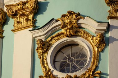 Ukrayna 'nın başkenti Kyiv' deki St. Andrew Kilisesi 'nin cephesinde yaldızlı bir barok süsü. İki melek dairesel bir pencere çerçevesi, solunda süslü bir Korint sermayesi var..