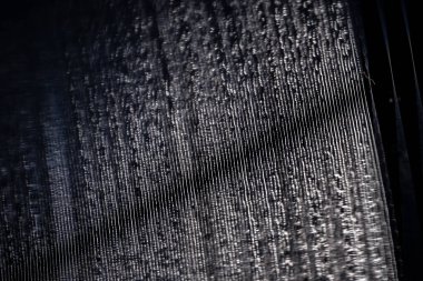 Plağın yüzeyine yakın çekim, müziği içeren karmaşık oluklara. Bu narin çizgilerin değişen yüksekliği ve derinliği ışığı yansıtıyor ve detaylı, dokulu bir desen oluşturuyor.