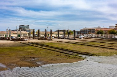 Santander, Cantabria, İspanya 'daki balıkçı limanında Rampa del cuadro. Su kenarından, endüstriyel binalar ve metal sütunlarla çalışan bir tersaneye kadar uzanan kayık raylarının üzerindeki tekne beşiği.