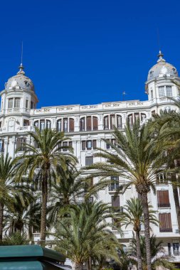 Casa Carbonell 'in tarihi mimarisi. Palmiye ağaçları Passeig Esplanada d' Espanya 'yı kaplıyor. Güneşli bir sonbahar gününde sakin bir şehir manzarasını yakalıyor..