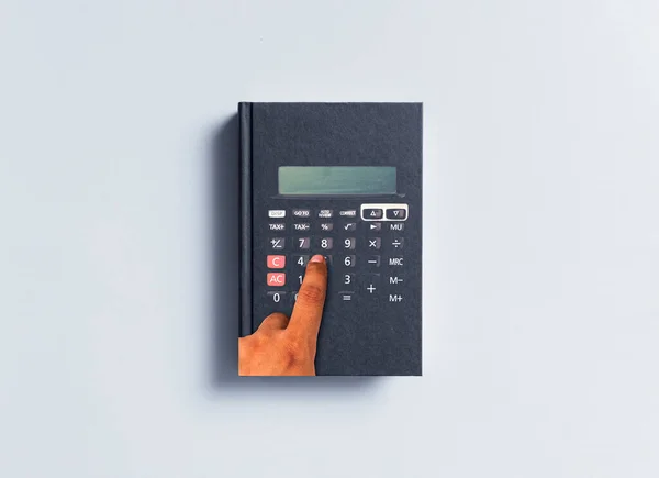 Education economics. Hand design that makes calculations on the book. The hand that calculates.