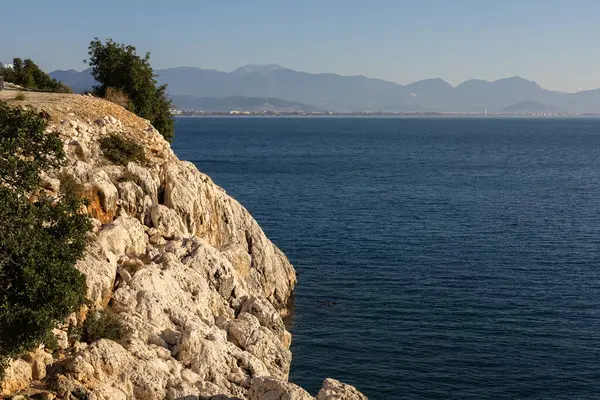 Kireçtaşı kayalıkları, dingin mavi suların üzerindeki yeşil kulelerle süslenmiş..