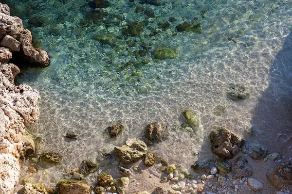 Sığ sular kayalık kıyı şeridini okşuyor