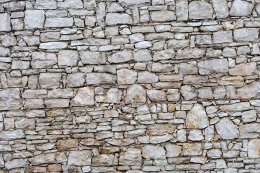 Detailed image of a rock wall showcasing diverse stone patterns and textures, highlighting natural color variations