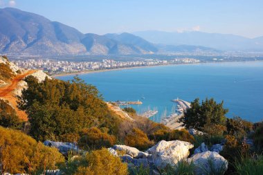 Türkiye 'nin Finike kentindeki sakin Akdeniz' e uzanan bir marina ve rıhtımın panoramik görüntüsü, tepeden görüldüğü gibi..