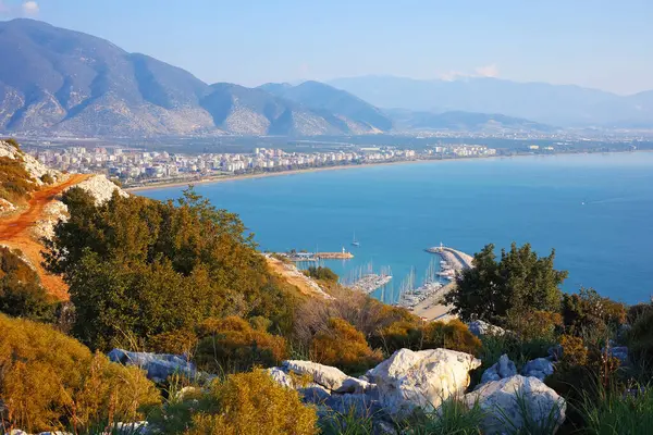 Türkiye 'nin Finike kentindeki sakin Akdeniz' e uzanan bir marina ve rıhtımın panoramik görüntüsü, tepeden görüldüğü gibi..