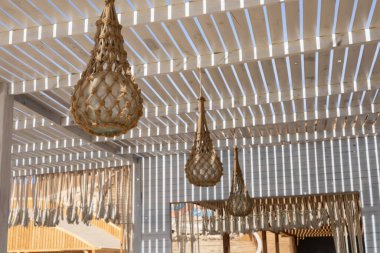 Sıcak bir atmosfer için örülmüş pergola altında örülmüş fenerlerle dolu kırsal bir avlu.