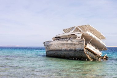 Terk edilmiş gemi enkazı berrak deniz kıyısında kristal berrak su ve mavi gökyüzüyle