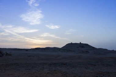 Çöl manzarası engin gökyüzü alacakaranlıkta ve yapıların siluetleri