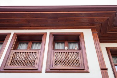 Yaşlı beyaz çift geleneksel binanın ahşap balkonundan gözlem yapıyorlar..