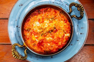 Geleneksel Türk erkekleri ellerinde domates ve biberle bakır tavada.