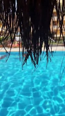 Sazlı çatıdan mavi havuz manzarası.