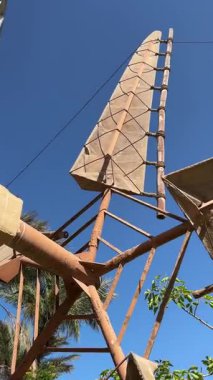 Açık mavi gökyüzüne ve ağaçlara karşı tarihi rüzgar kulesi