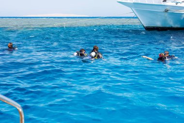 Hurghada, Mısır 'da, 2025 Ağustos' unda teknenin yanında dalgıçlar..