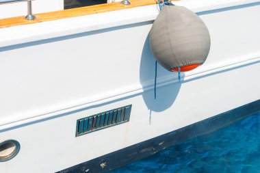 Tekne çamurluğu yatın kenarında asılı..