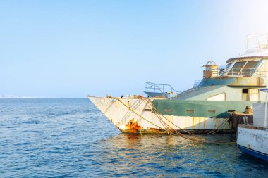 Paslı gemi güneşli limana yanaştı..