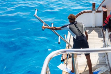 Dalgıç açık mavi denize girmeye hazırlanıyor..