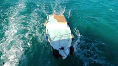 Turkuaz okyanus suyundaki küçük ahşap tekne..