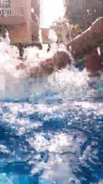 Su sıçrıyor, ayakları havuzda.