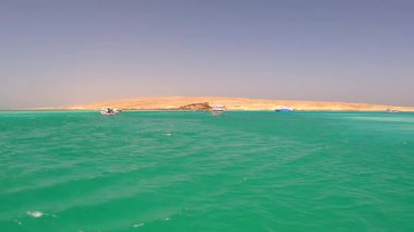 Turkuaz denizdeki tekneler kumlu adanın yanında